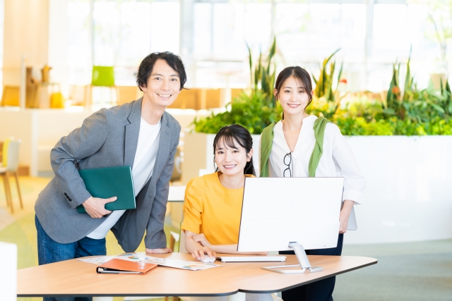 こちらを見る3人のオフィスワーカー